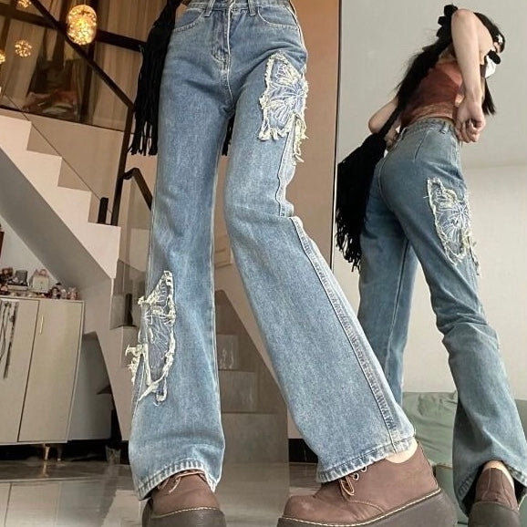 Jeans svasati con farfalle di strass