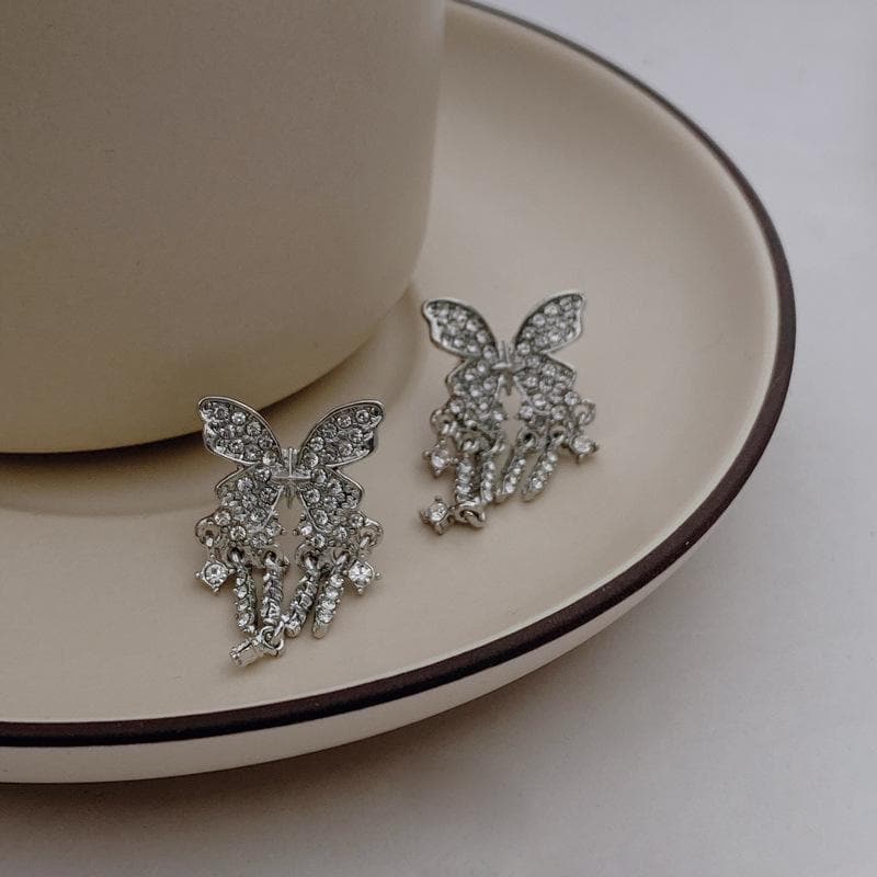 Orecchini con ciondolo a farfalla e nappe in strass