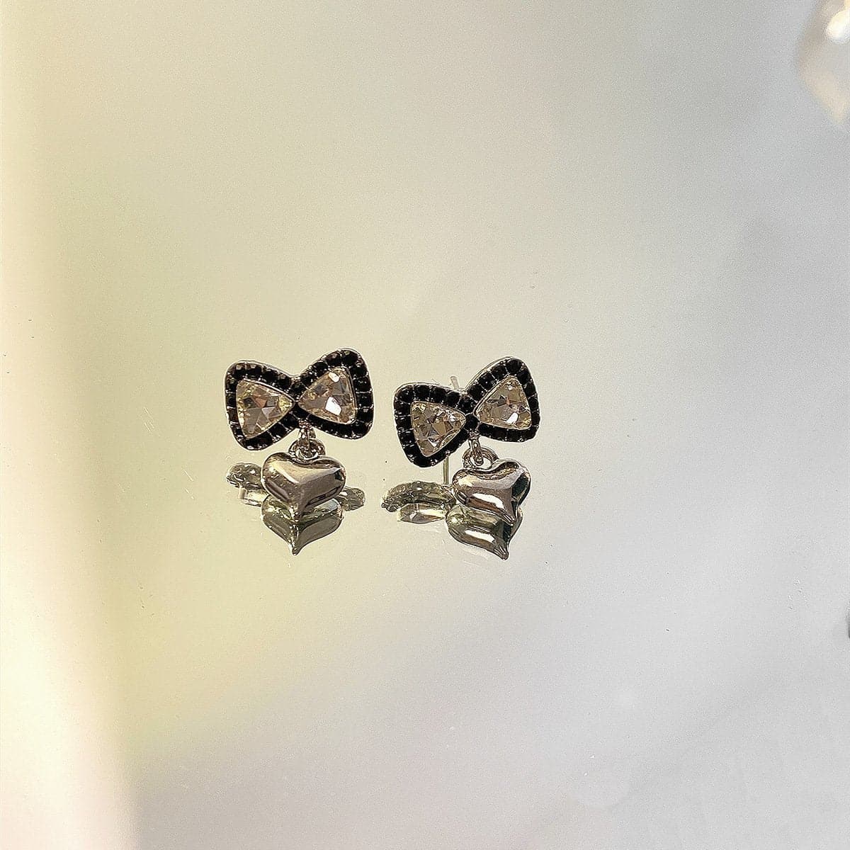 Orecchini con ciondolo a forma di cuore e fiocco in strass